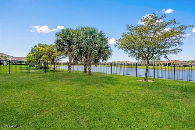 view of yard with a water view and fence