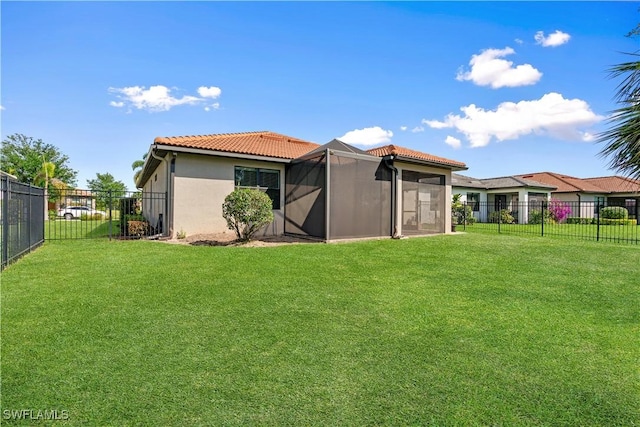 back of house with a yard, a fenced backyard, stucco siding, and a tile roof