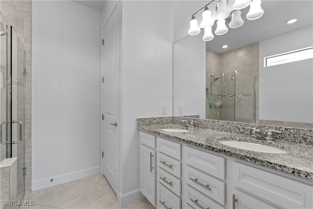 full bathroom with a sink, baseboards, a shower stall, and double vanity