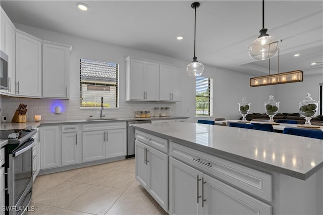 kitchen featuring decorative backsplash, a sink, white cabinets, and stainless steel appliances