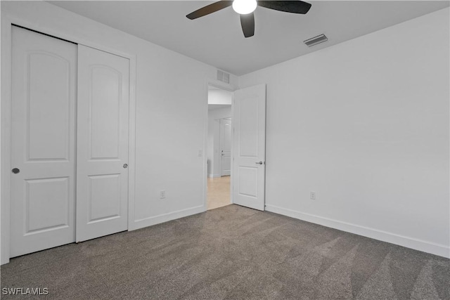 unfurnished bedroom with a closet, visible vents, baseboards, and carpet