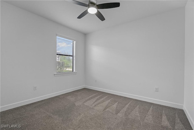 empty room featuring baseboards, a ceiling fan, and dark colored carpet