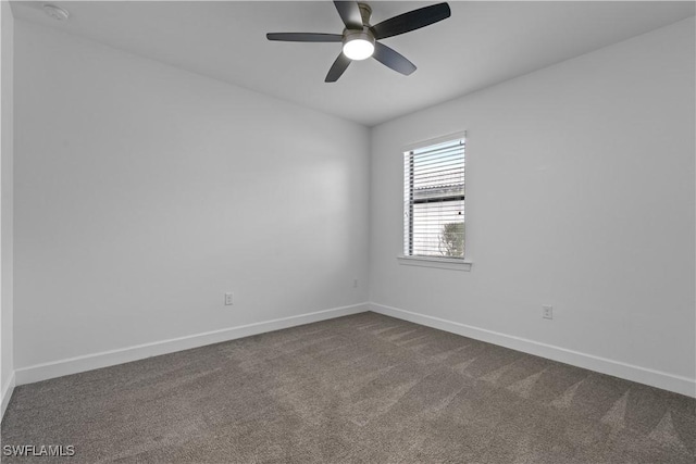 empty room featuring dark carpet, baseboards, and a ceiling fan