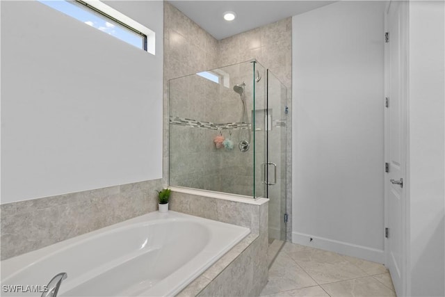 full bath featuring a shower stall, a bath, and baseboards