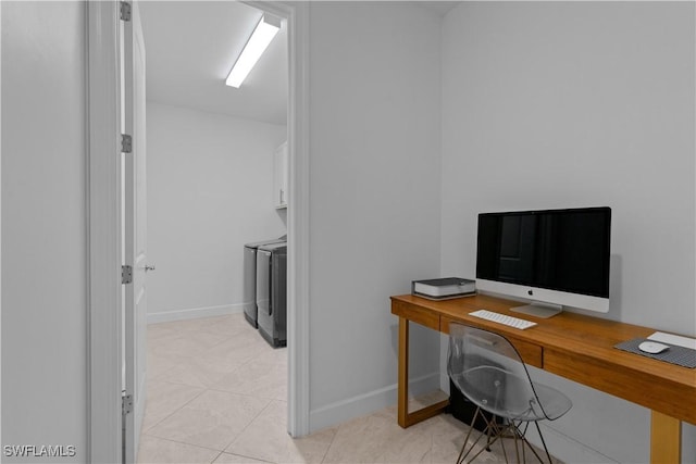 office featuring washer and dryer, light tile patterned floors, and baseboards