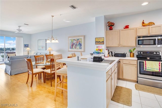 kitchen with open floor plan, a peninsula, visible vents, stainless steel appliances, and light brown cabinetry