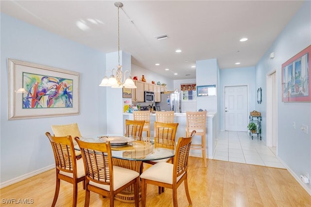 dining space featuring visible vents, light wood-type flooring, an inviting chandelier, and recessed lighting