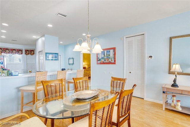 dining space featuring visible vents, recessed lighting, wood finished floors, baseboards, and a notable chandelier