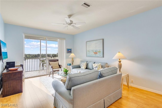 living area with light wood-style floors, visible vents, baseboards, and ceiling fan