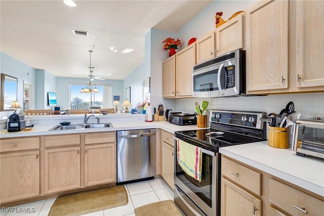 kitchen with light brown cabinetry, visible vents, light countertops, a sink, and stainless steel appliances
