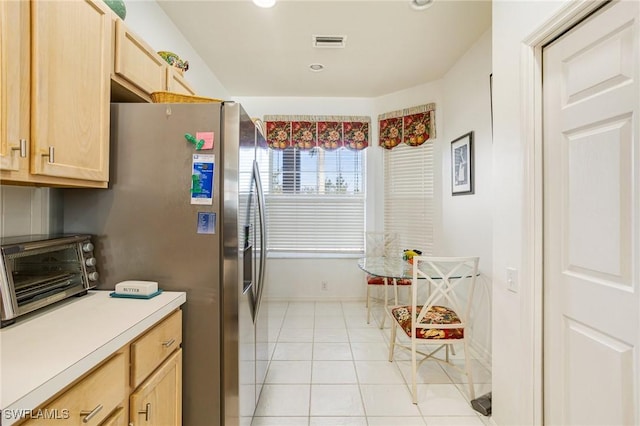 kitchen with light tile patterned floors, visible vents, and light brown cabinets