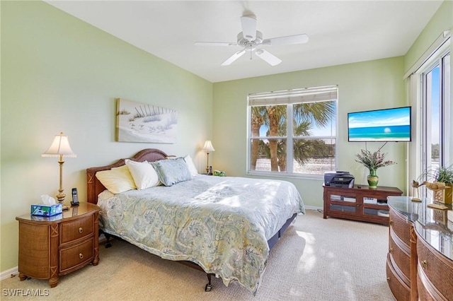 bedroom featuring light carpet, ceiling fan, and baseboards