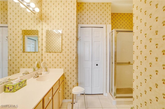bathroom featuring vanity, a closet, wallpapered walls, tile patterned flooring, and a shower stall