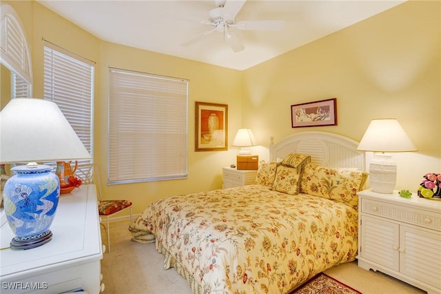 bedroom featuring light carpet and a ceiling fan