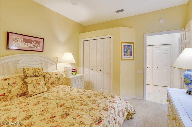 bedroom featuring light carpet, visible vents, baseboards, and a ceiling fan