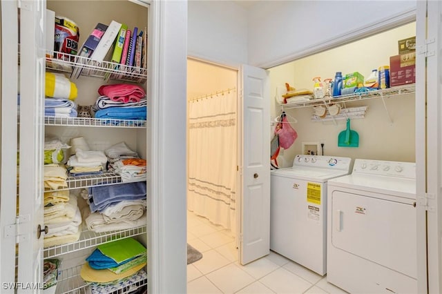 washroom with washer and dryer, laundry area, and light tile patterned flooring