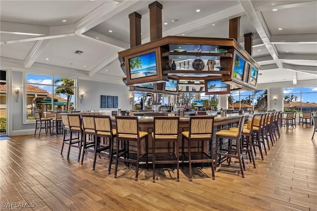 bar featuring visible vents, a community bar, beam ceiling, and wood finished floors