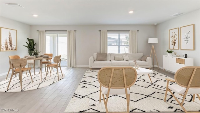 living area featuring light wood finished floors, baseboards, visible vents, and recessed lighting