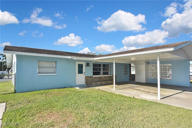 8150 Cleaves Rd, North Fort Myers, FL 33903 - back of house featuring a carport, a yard, stucco siding, and fence