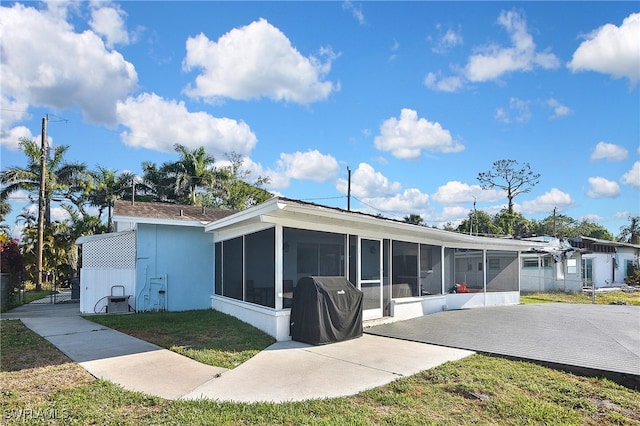 8150 Cleaves Rd, North Fort Myers, FL 33903 - rear view of house featuring a yard, stucco siding, and a sunroom