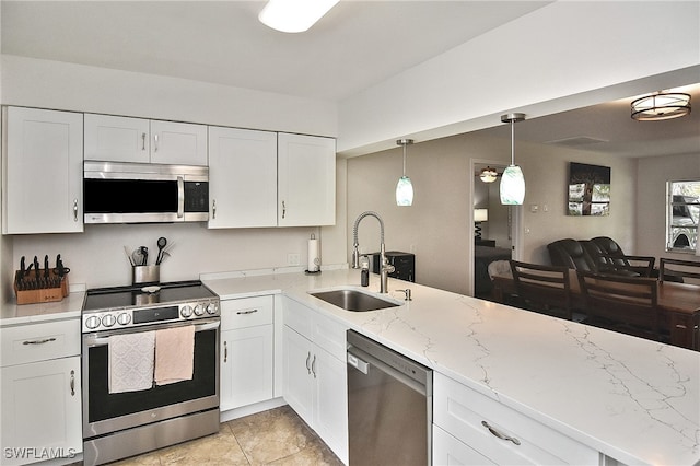 8150 Cleaves Rd, North Fort Myers, FL 33903 - kitchen with stainless steel appliances, light stone countertops, white cabinets, and a sink