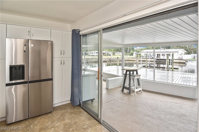 8150 Cleaves Rd, North Fort Myers, FL 33903 - kitchen featuring stainless steel fridge, white cabinets, and a water view