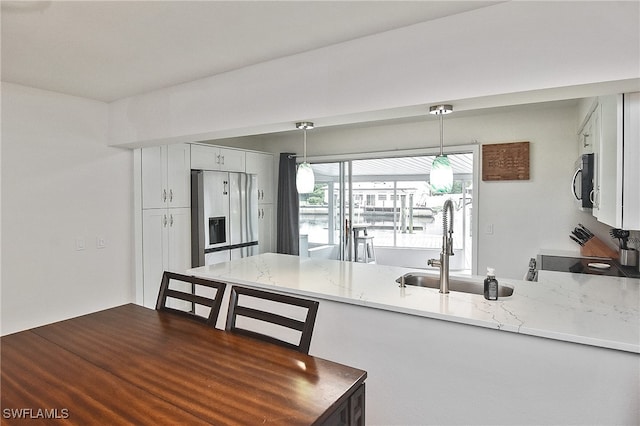 8150 Cleaves Rd, North Fort Myers, FL 33903 - kitchen with light stone countertops, a peninsula, a sink, hanging light fixtures, and stainless steel appliances