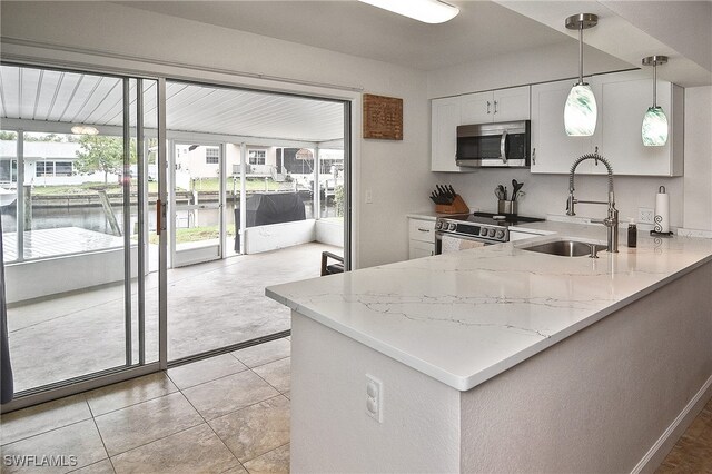 8150 Cleaves Rd, North Fort Myers, FL 33903 - kitchen with light stone counters, a sink, plenty of natural light, and stainless steel appliances