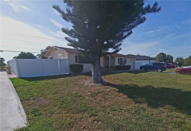 exterior space with a front yard, an attached garage, fence, and stucco siding
