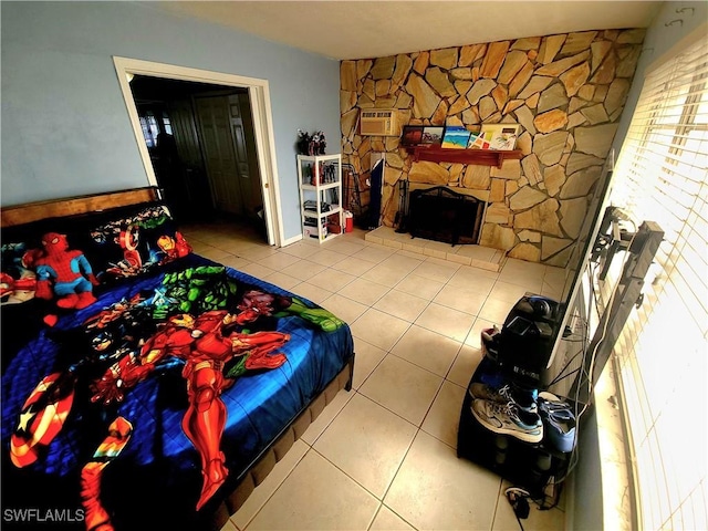 tiled bedroom with a stone fireplace and a wall unit AC