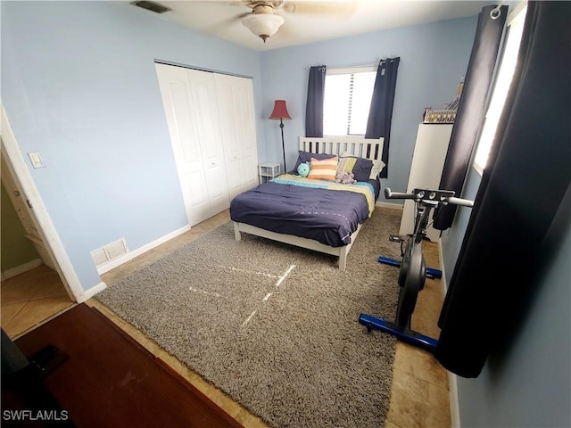 bedroom featuring visible vents, a closet, baseboards, and a ceiling fan