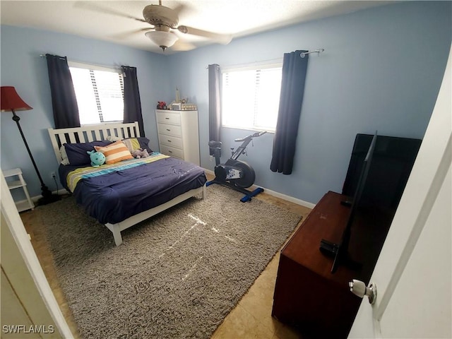 bedroom with baseboards, multiple windows, and a ceiling fan