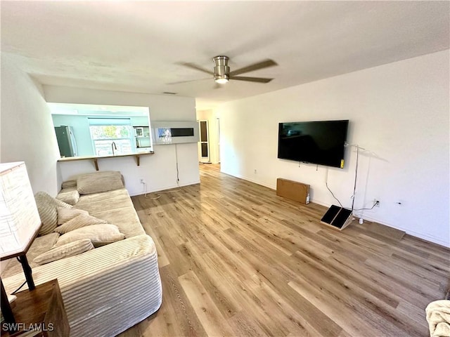 living room featuring ceiling fan and light wood-style floors
