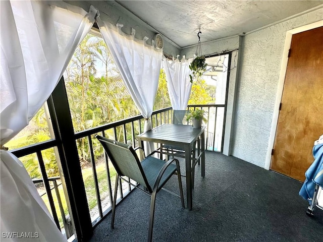 sunroom / solarium featuring a textured wall and a healthy amount of sunlight