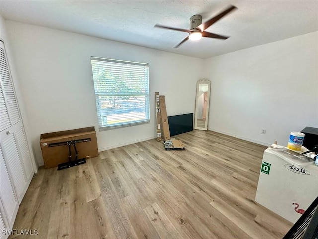 unfurnished living room with wood finished floors, a ceiling fan, and baseboards