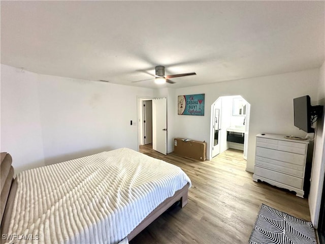 bedroom featuring visible vents, ensuite bathroom, a ceiling fan, and light wood finished floors