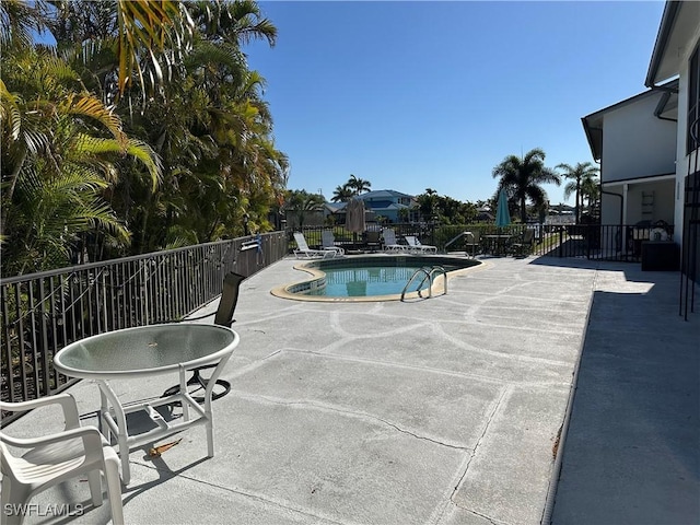 pool featuring fence and a patio area