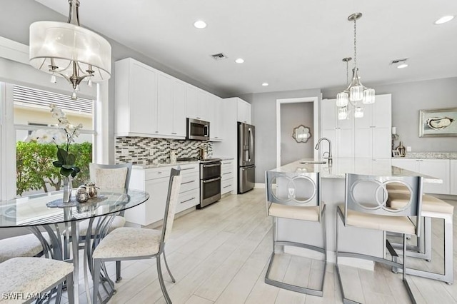 61 N Barfield Dr, Marco Island, FL 34145 - kitchen featuring appliances with stainless steel finishes, a chandelier, a sink, tasteful backsplash, and recessed lighting