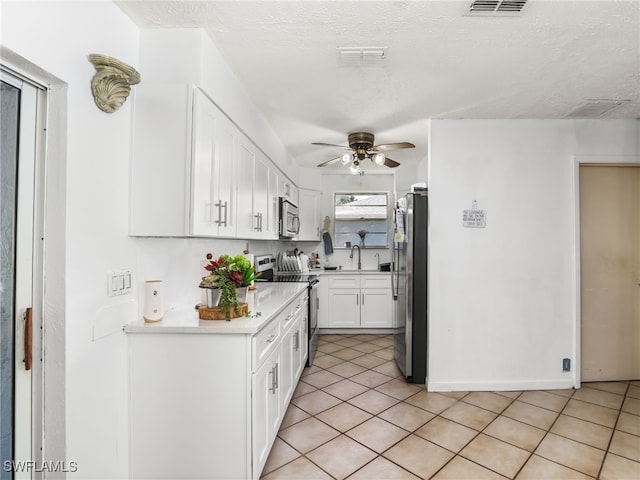 kitchen with a ceiling fan, white cabinets, visible vents, appliances with stainless steel finishes, and light countertops