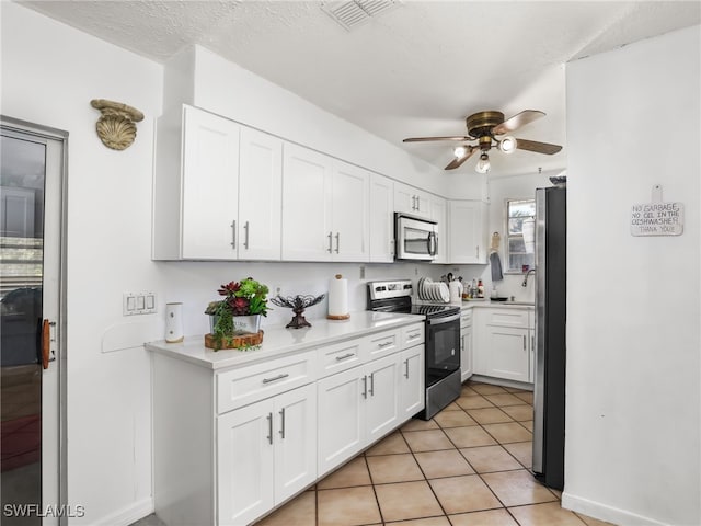 kitchen with white cabinetry, a ceiling fan, light tile patterned flooring, visible vents, and appliances with stainless steel finishes