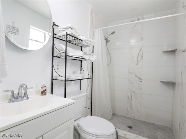 bathroom featuring a tile shower, toilet, and vanity