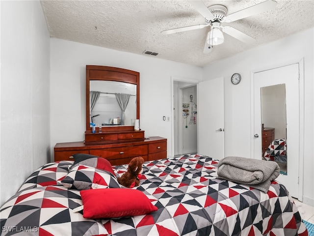 bedroom featuring visible vents, a textured ceiling, and ceiling fan