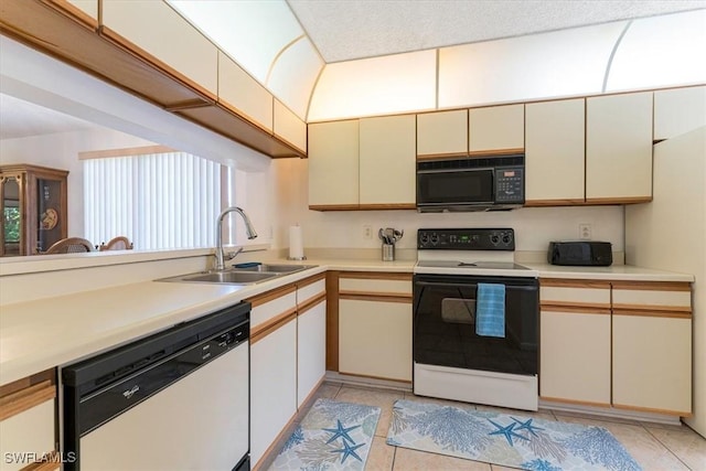 232 Pebble Beach Cir Unit E104, Naples, FL 34113 - kitchen with range with electric stovetop, black microwave, dishwasher, a sink, and cream cabinets
