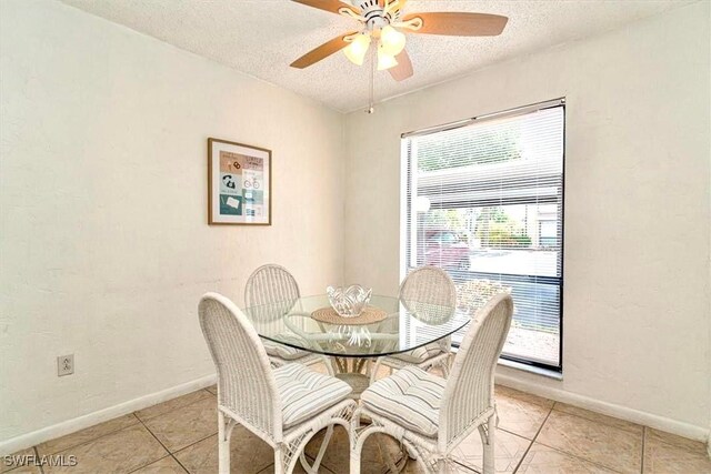 232 Pebble Beach Cir Unit E104, Naples, FL 34113 - dining space featuring a textured ceiling, baseboards, a ceiling fan, and light tile patterned flooring
