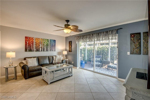 living area featuring light tile patterned floors, baseboards, and ceiling fan