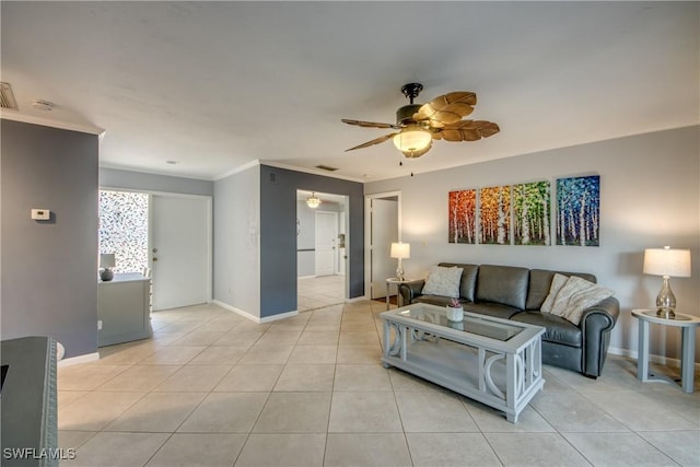 living room featuring light tile patterned floors, baseboards, crown molding, and ceiling fan