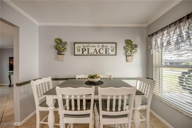 dining room featuring light tile patterned floors, baseboards, and ornamental molding