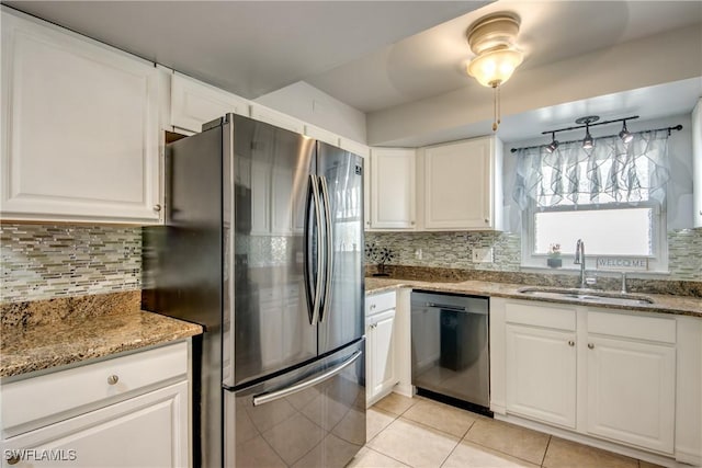 kitchen with tasteful backsplash, a sink, white cabinetry, stainless steel appliances, and light stone counters