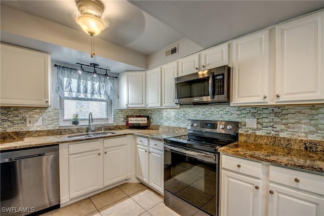 kitchen with a sink, backsplash, white cabinets, and stainless steel appliances