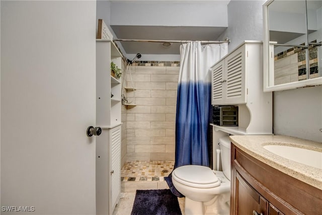 bathroom with toilet, vanity, and a stall shower